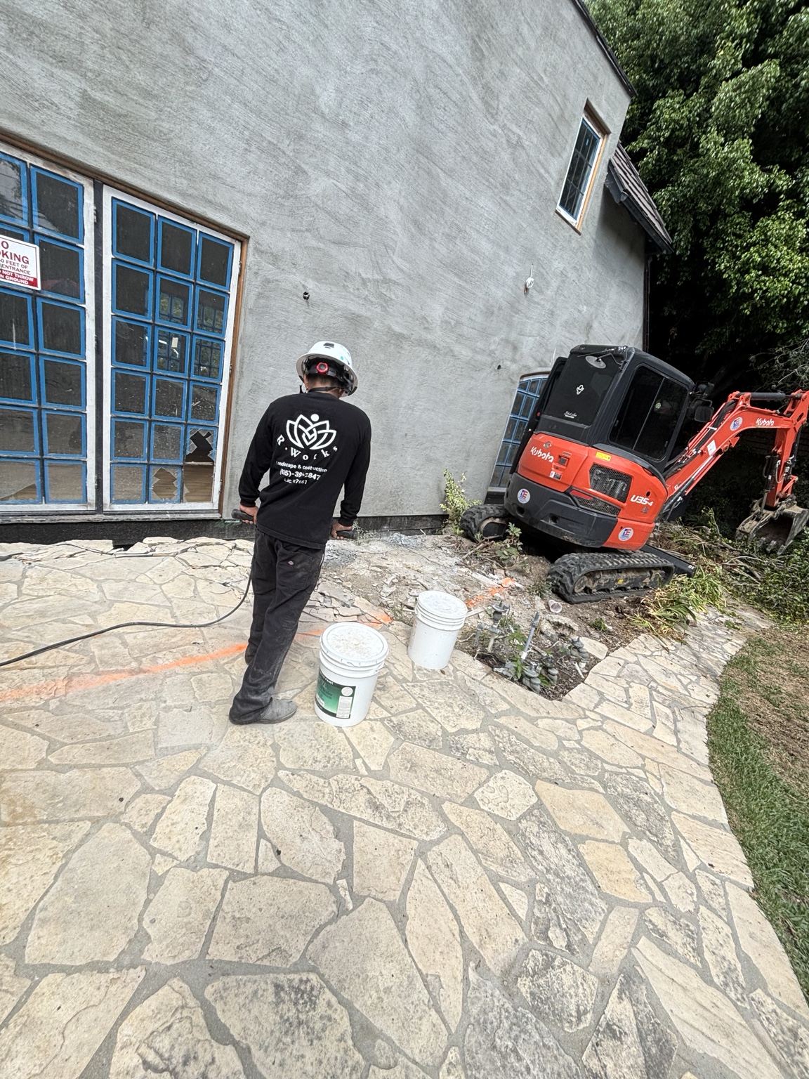 R.T. Works crew member and excavator during outdoor demolition