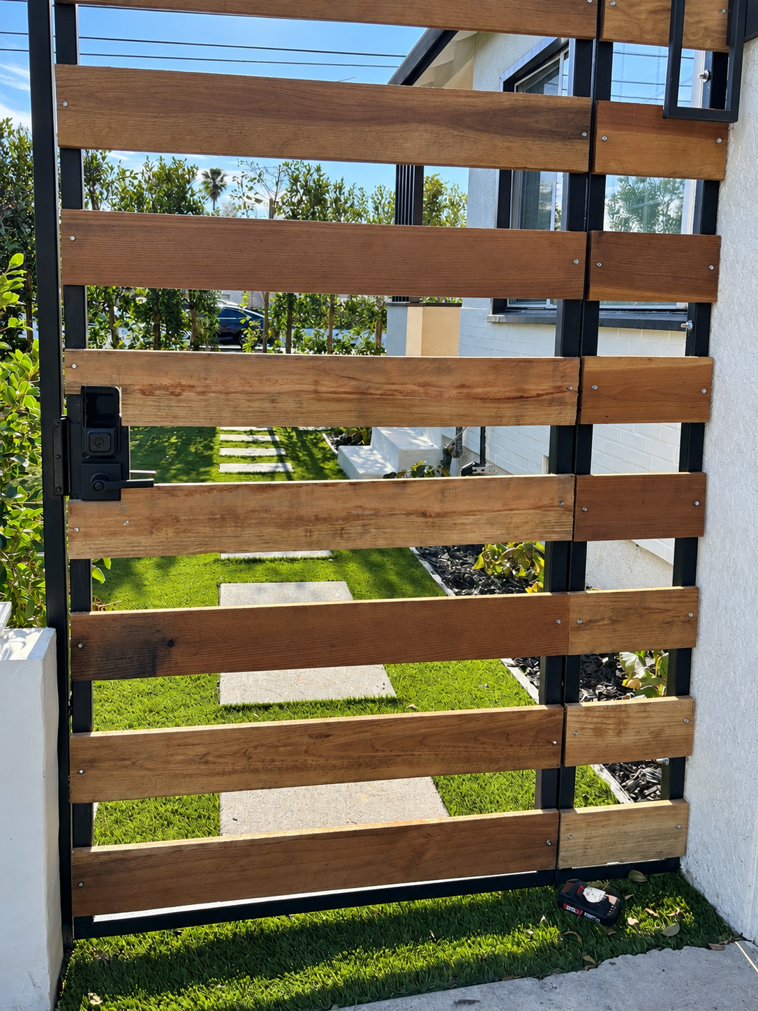 Horizontal wood slat gate with black metal frame