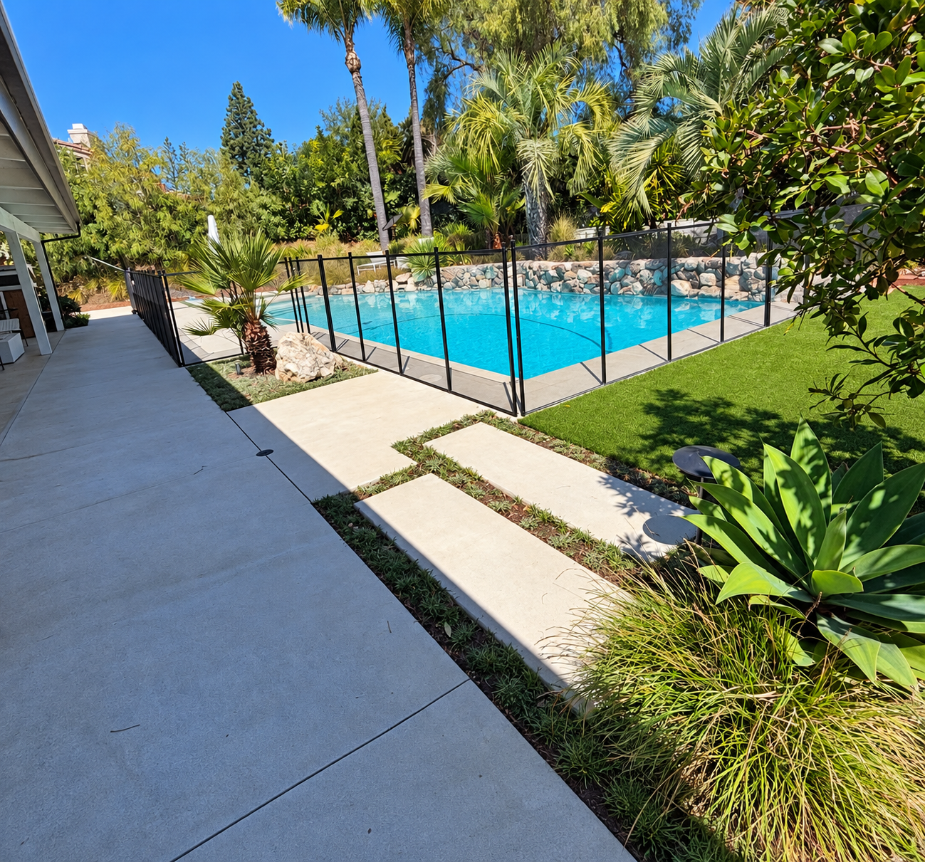 Turf, planting and stepping stones alongside an existing swimming pool